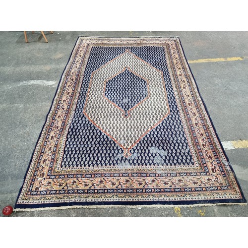 342 - A handwoven Anatolian Turkish rug in shades of blue and orange with a geometric border and central l... 