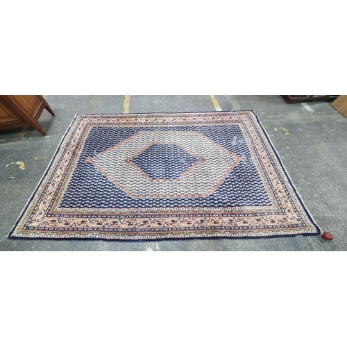 342 - A handwoven Anatolian Turkish rug in shades of blue and orange with a geometric border and central l... 