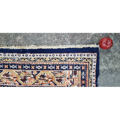 342 - A handwoven Anatolian Turkish rug in shades of blue and orange with a geometric border and central l... 