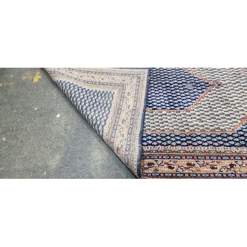 342 - A handwoven Anatolian Turkish rug in shades of blue and orange with a geometric border and central l... 