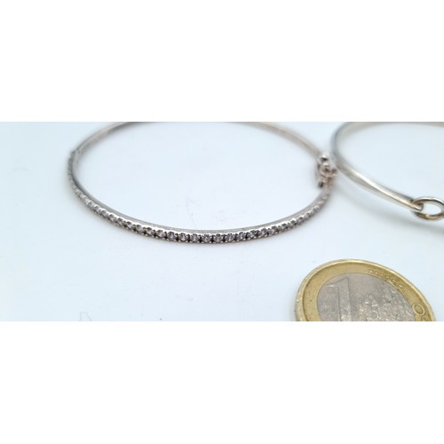 803 - Three sterling silver bangles (marked 925) including a blue gem set example with scroll setting, a l... 