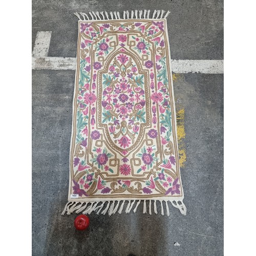 334 - A gorgeous hand made rug featuring a fabulous knitted pattern of intricate flowers in shades of pink... 