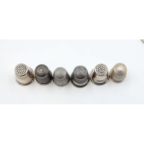 524 - A collection of six sterling silver thimbles. Of particular interest, a Thimble by the notable maker... 