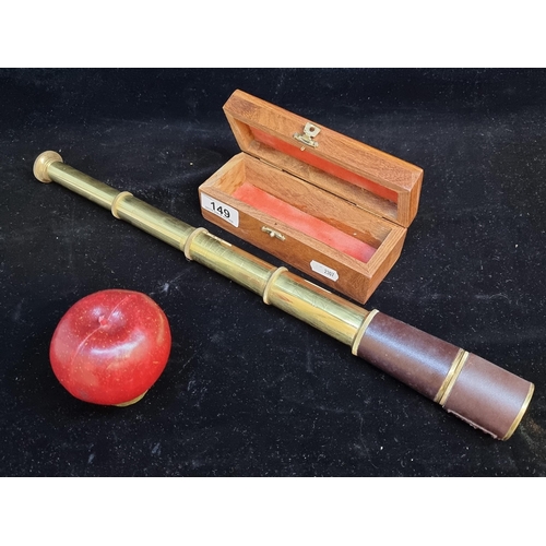 149 - A redwood display box for a neat sized triple draw pocket telescope. With brass body and leather sty... 