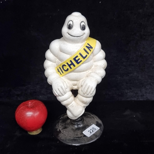 228 - A charming figure depicting the Michelin man sitting on a high stool.