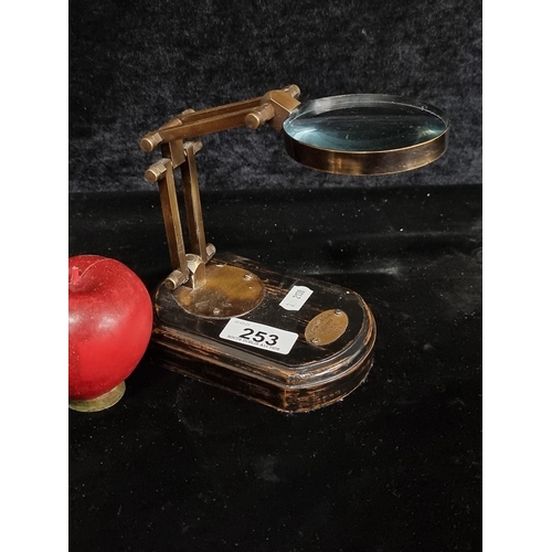 253 - A nice jewelers articulated magnifying glass with a plaque to wooden base reading 