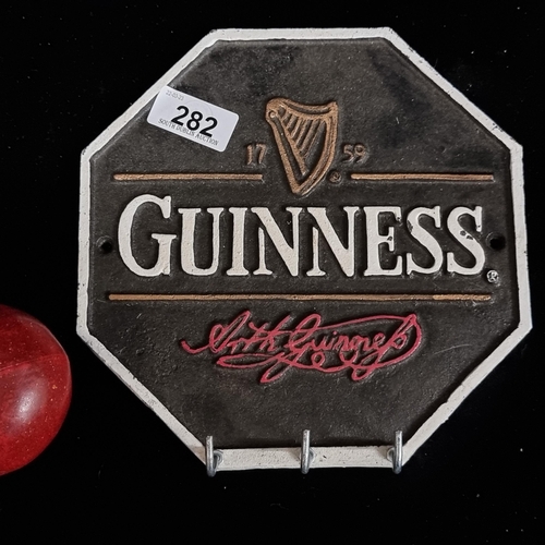 282 - A cast metal advertising sign for Guinness stout in an octagonal shape. Designed in black with a cla... 