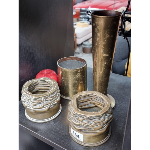 554 - Four brass items including a WW1 trench art example. Including a fabulous pair of pillar candle hold... 