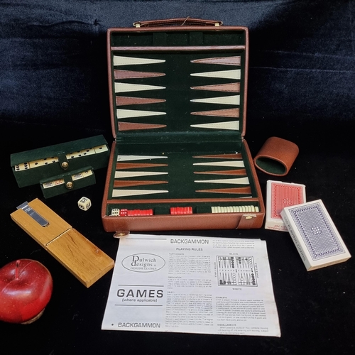 173 - A Dulwich Designs travel games set. Including backgammon, dominos, chess, cribbage, poker dice and c... 