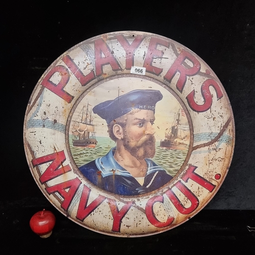 66 - A circular metal wall sign reading Players Navy Cut, with the iconic sailor in a life saving ring.