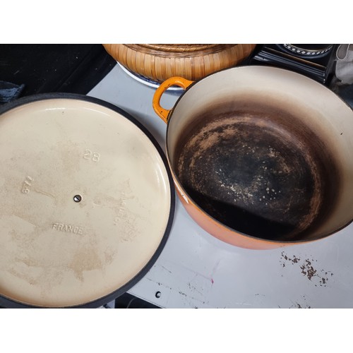 137 - A large cast iron lidded casserole dish by renowned French makers Le Creuset. In their iconic orange... 