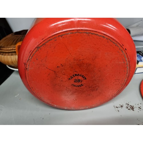 137 - A large cast iron lidded casserole dish by renowned French makers Le Creuset. In their iconic orange... 