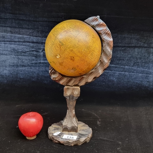 135 - A handsome neatly proportioned World globe with a hand carved wooden base. H37cm