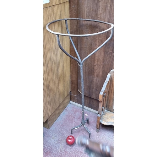 368 - A heavy cast iron plant stand tripod with pronged base for placement in the ground and a circular ho... 