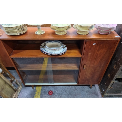 497 - A handsome Mid Century Modern sideboard with sliding glass doors revealing an internal shelf, and a ... 