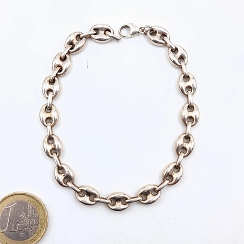 507 - A sterling silver heavy gauge link chain and space bracelet. Set with a lobster clasp and with a wei... 