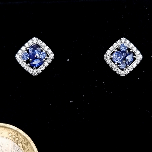 539 - A sparkling pair of sterling silver Tanzanite stone stud earrings, set with beautiful White Sapphire... 