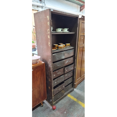 551 - An industrial storage cabinet with shelving space to top and twelve deep pull out drawers to base. I... 