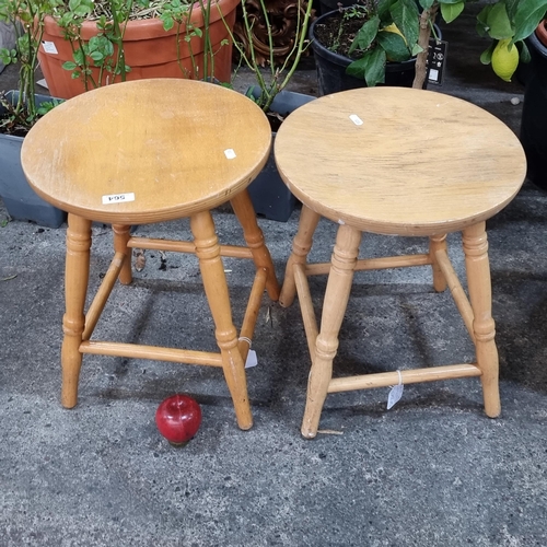 564 - A pair of low wooden stools with four turned legs connected by stretchers.