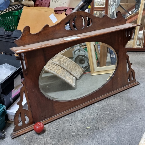 577 - An elegant, vintage over-mantle mirror with sinuous pierced detail and bevelled central oval mirror.... 