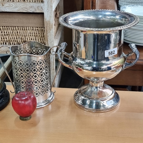 582 - Two vintage silver plated items including an ice bucket with two handles and a pierced wine bottle h... 