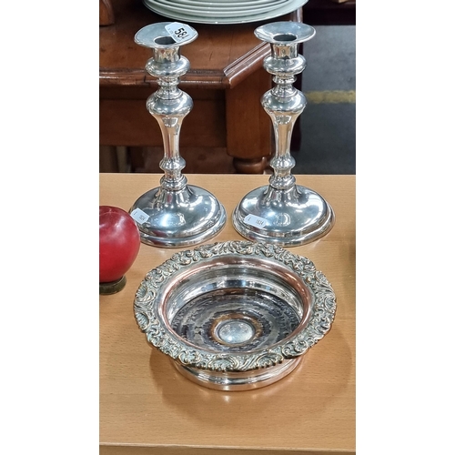 584 - Three vintage silver plated items including a pair of candle holders with candle pushers, and an ele... 