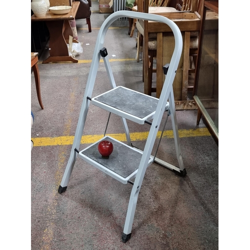 594 - A useful A frame stepladder with two steps, in a white finish. Steps lined with grip material for ex... 