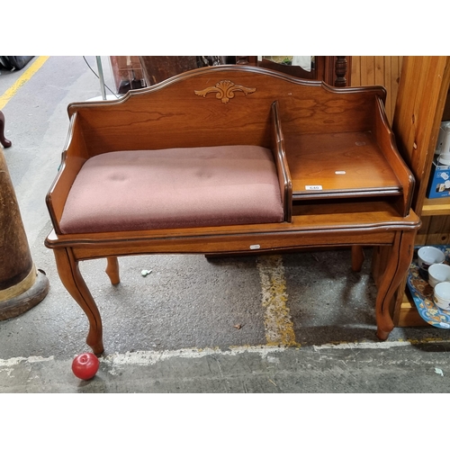 640 - A beautiful example of a vintage telephone bench. Of wonderfully curved form with a carved frame and... 