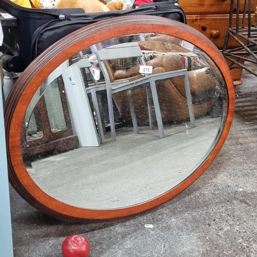 675 - A wonderful large vintage oval beveled mirror set in to a handsome carved frame.