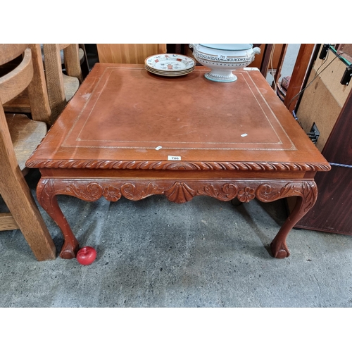 706 - A striking square form coffee table. Featuring a beautiful red wood and carved apron sporting floral... 