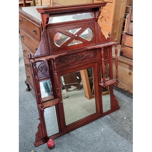 717 - An over mantle mirror with integrated étagère shelving. Featuring seven beveled mirrors and carved e... 