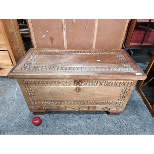 719 - A heavy storage chest crafted from wood with heavy brass hardware and carved detail. A well construc... 