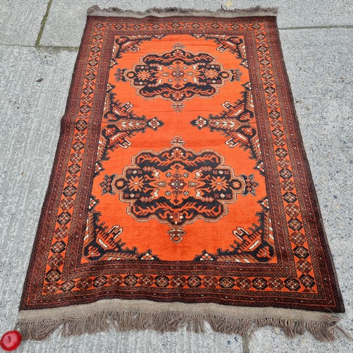 567 - Star lot : A pretty handmade, hand knotted rug in shades of red, brown and black boasting a detailed... 