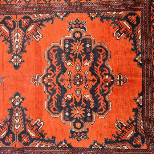 567 - Star lot : A pretty handmade, hand knotted rug in shades of red, brown and black boasting a detailed... 