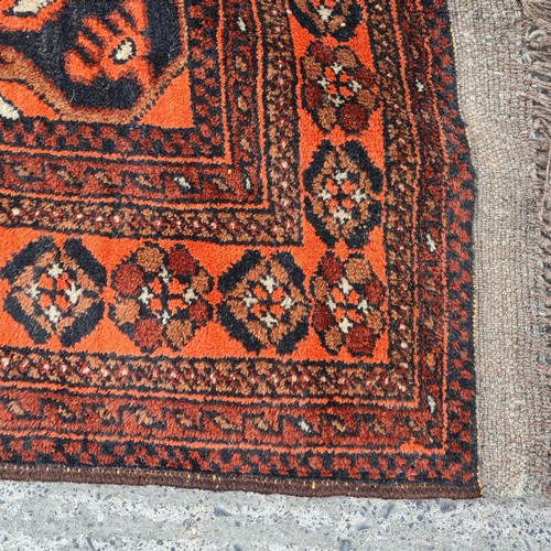 567 - Star lot : A pretty handmade, hand knotted rug in shades of red, brown and black boasting a detailed... 