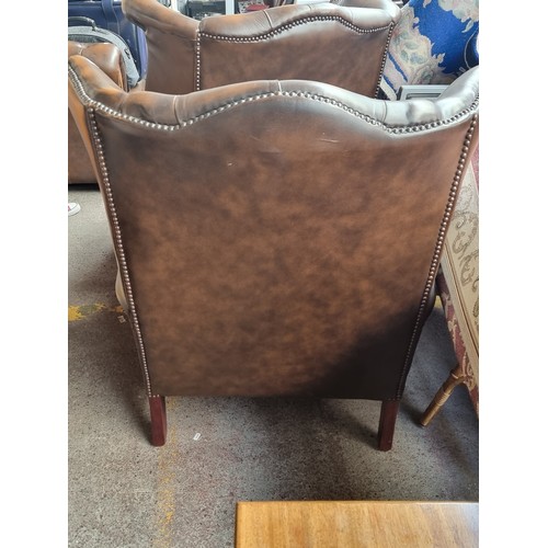 633 - Star Lot : Two super clean dark brown leather wingback Chesterfierld  armchairs with diamond button ... 