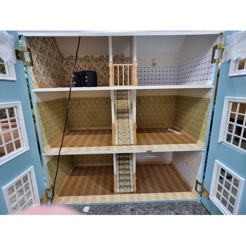 685 - A wonderful three story dolls house. This grand example is wonderfully outfitted with wallpapered ro... 