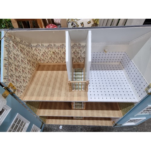 685 - A wonderful three story dolls house. This grand example is wonderfully outfitted with wallpapered ro... 