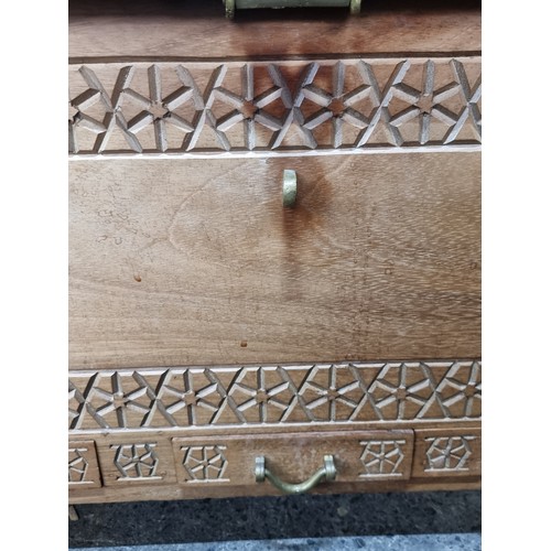 719 - A heavy storage chest crafted from wood with heavy brass hardware and carved detail. A well construc... 