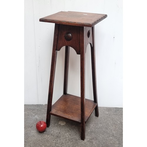 580 - A nice example of an Arts and Crafts wooden plant stand with splayed legs and a shelf to base.