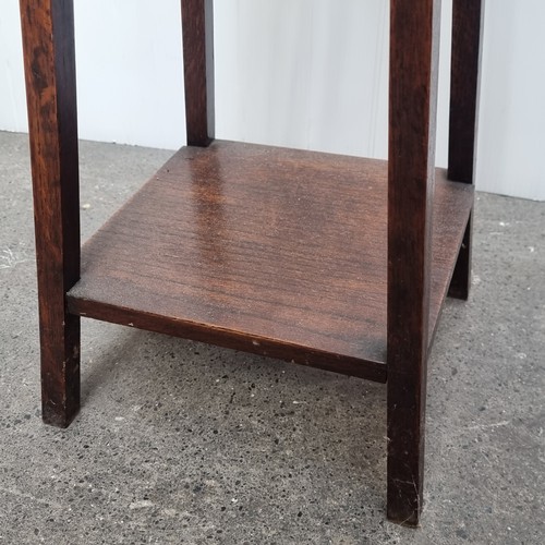 580 - A nice example of an Arts and Crafts wooden plant stand with splayed legs and a shelf to base.