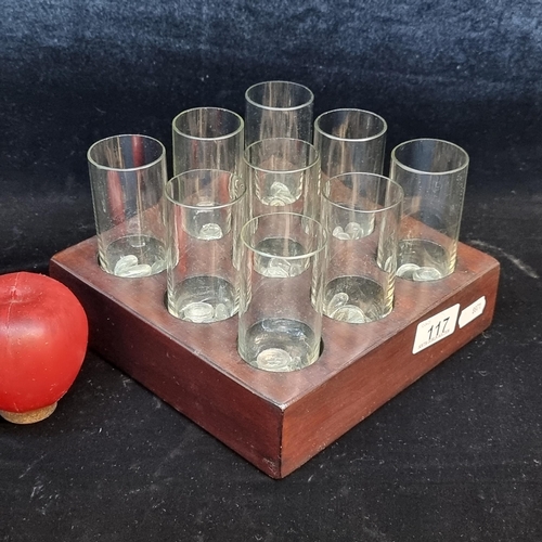 117 - A set of nine glasses with a solid wooden display base and decorative glass stones.