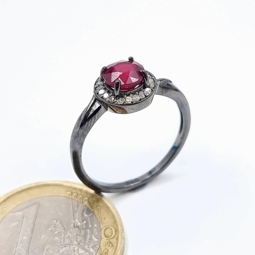 19 - A striking example of a Ruby and Diamond ring, featuring a central Ruby of .5 carats and a surround ... 