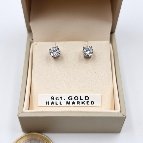 22 - An attractive pair of 9 carat white gold stud earrings, featuring sparkling bright Zircon stones. En... 