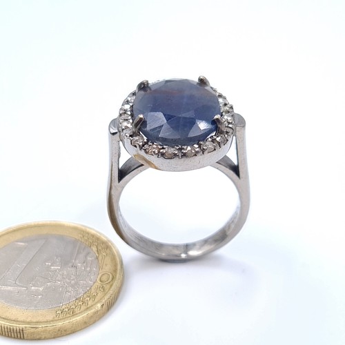 8 - Star Lot : A striking example of an unusual shade of  Blue Sapphire and Diamond ring, set with a cen... 