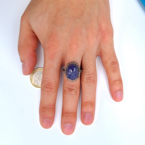 9 - Star Lot : An exquisite cabochon Tanzanite and Diamond ring, featuring a generously large 12.3 carat... 