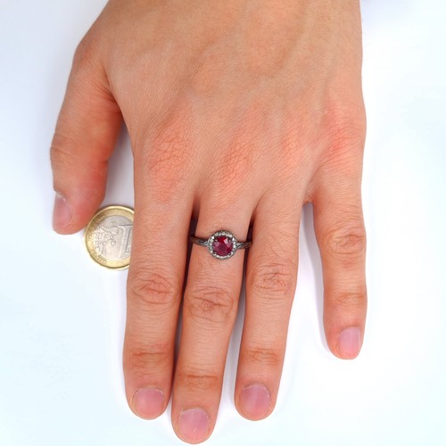 19 - A striking example of a Ruby and Diamond ring, featuring a central Ruby of .5 carats and a surround ... 