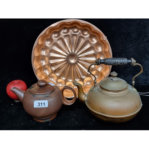 311 - Three kitchen items including an antique copper stove top kettle with turned wood handle, a stonewar... 