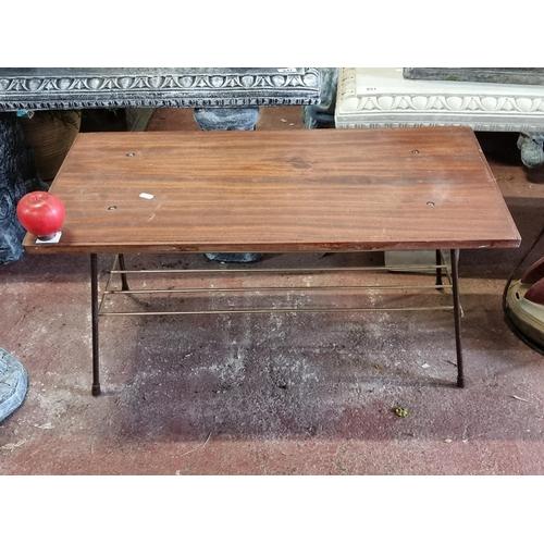 964 - A vintage coffee table of Mid Century design. Featuring a a stained wood top and cast metal wire tie... 