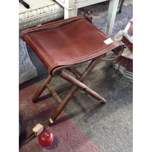 966 - An unusual vintage folding stool. Designed with a genuine leather seat and buckle detailing. Support... 